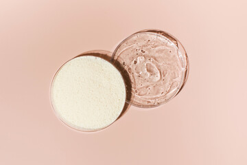 Samples of collagen powder and hyaluronic acid in Petri dishes on a pink background close-up view from above