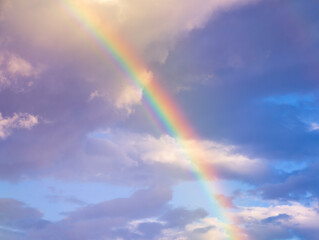 amazing bright rainbow in beautiful evening cloudy sky after rain and thunder, weather concept