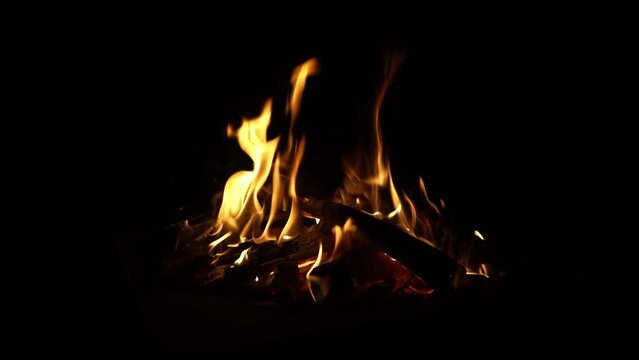 Fire flames on a black background. Flame border close up. Sparks from a campfire over a dark night background. Christmas background, Slow motion.