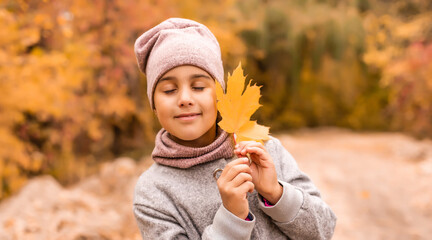 autumn outdoor portrait of beautiful happy child girl walking in park or forest in warm knitted...