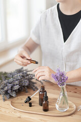 Using natural essential oil in a home spa ritual. A woman takes care of her skin and hair.