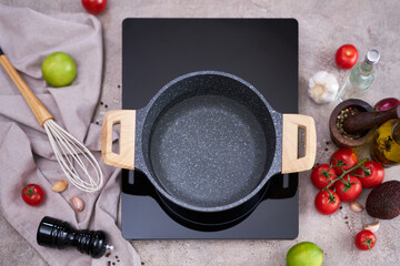 Boiling water in a cooking pot an a pan on a induction stove at domestic kitchen