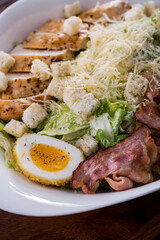 Salad with bacon, ham, boiled egg, cheese