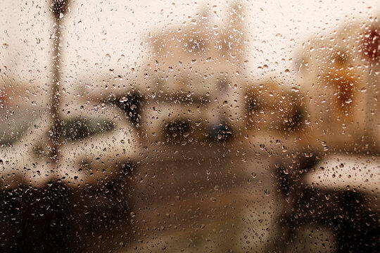 Rainy city background. Raindrops on window glass on autumn day. Wet home window with raindrops. High quality photo