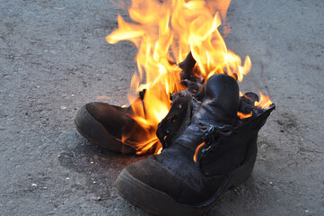 Burning shoes close-up. Burning work shoes shoes.