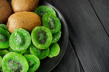 green dried kiwi on a black wooden rustic background