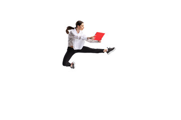 Portrait of young woman, office employee in official suit reading papers in a jump isolated over white studio background