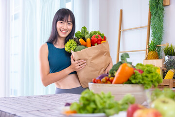 Asian Japanese woman holding shopping bag from supermarket full of organics vegetables and fruits for healthy food and vegetarian salad with copy space