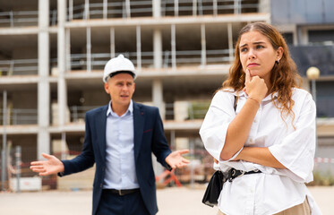 Fototapeta premium Portrait of a frustrated young woman who had a misunderstanding with a man contractor about cooperation