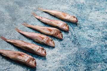 A few fresh Black Sea red mullet on a blue background.