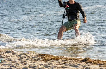 Expert Kitesurfer Planing close to the beach with Pictoresque Sea Watrer Splashes at sunset