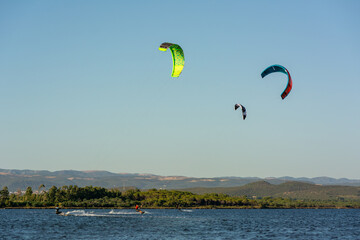 Kitesurfers riding near Punta Trettu, near Cagliari, in Sardinia, Italy, at Golden hour on Blurred...