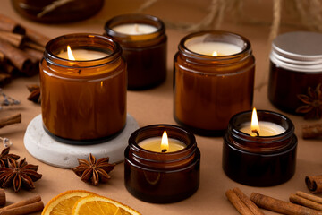 A set of different aroma candles in brown glass jars. Scented handmade candle. Soy candles are burning in a jar. Aromatherapy and relax in spa and home.