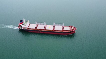 a large bulk carrier transports grain at sea, aerial view