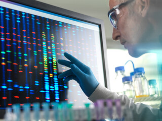 Scientist viewing DNA sample results on screen during clinical experiment