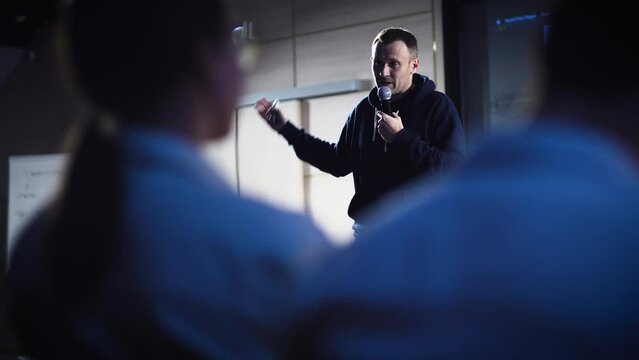 Conference in the IT industry. A young and successful male speaker talks about modern solutions to students and colleagues.
