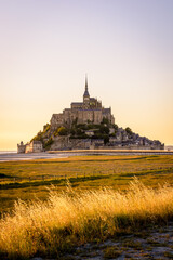 The Mont Saint-Michel tidal island at sunset in Normandy, France.