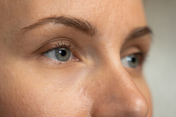 Close-up of a beautiful young woman with blue eyes looking sideways. 