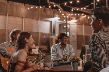 Group of young friends enjoying meal and celebrating friendship in pub and restaurant
