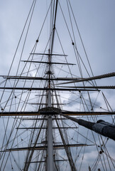 Sailing ship masts and rigging on sky background