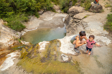 A woman with her son in a river in summer cooling off in the Pyrenees