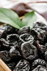 delicious dried prunes on a wooden rustic background
