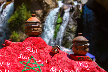 Two moroccan Tajines in front of a big waterfall in Imlil Morocco