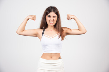 Fototapeta premium Picture of young sporty woman showing her biceps