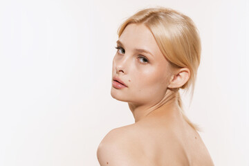 Fototapeta premium Young beautiful girl with blond glossy hair and without makeup isolated on white studio background. Spa, cosmetics, wellbeing and skin care concept