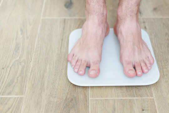 a man stands on a floor scale on the floor close-up