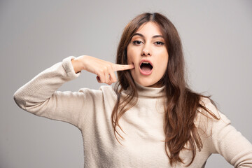 A young woman with finger point to her dimples