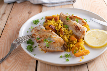 Healthy fish dish with redfish fillet served with turmeric rice and roasted carrots