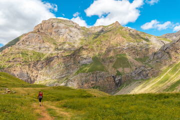 Fototapeta na wymiar A young woman on mountain trekking with her son in the Ripera valley in summer, Pyrenees