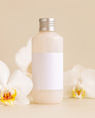 Obraz na płótnie Canvas Cosmetic bottle with blank label near white orchid flowers on light yellow, Mockup