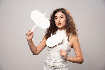 Young woman holding two blank white posters