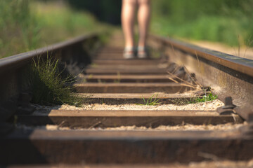 Closeup of a person walking on the railway on a sunny day - new opportunities