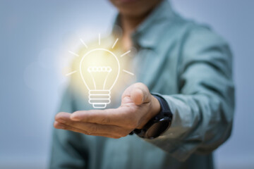 Close-up of man showing light bulb icon on hand, concept of scientific technology, innovation ideas, creativity and energy saving.