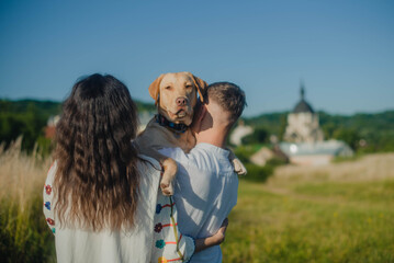 Portrait of a labrador on the shoulder of a maried couple isolated on field city view background