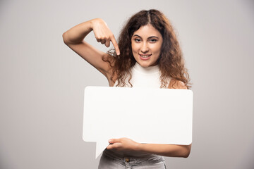 Young woman holding empty blank white speech poster