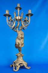 Fototapeta na wymiar classic bronze chandelier with a figure of woman, ancient candlestick studio photo, antique candlestick isolated, brass chandelier, one vintage candlestick, bronze candle tree on blue background