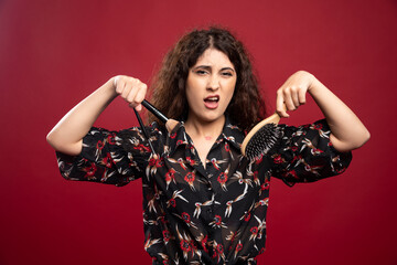 Woman holding makeup brushes and comb