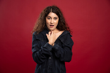 Beautiful curly woman looking at camera on red background