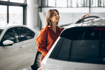 Woman choosing a car in a car showroom