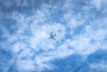 Fototapeta na wymiar Lecący samolot na tle nieba. Błękit nieba i białe chmury.