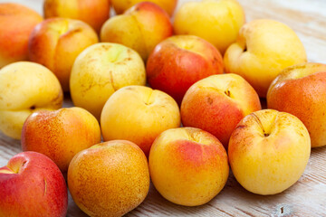 Closeup of whole ripe apricots on wooden background. Harvest time