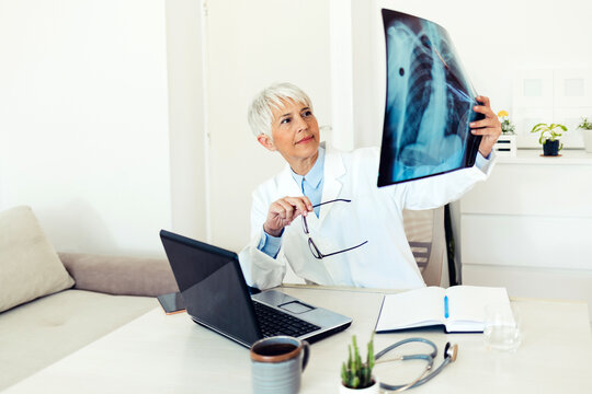 Shot of a maturee doctor analyzing an x ray of a patient’s chest. Shot of a senior doctor reading the results of an x ray in her consulting room. Healthcare, radiology and medicine concept.