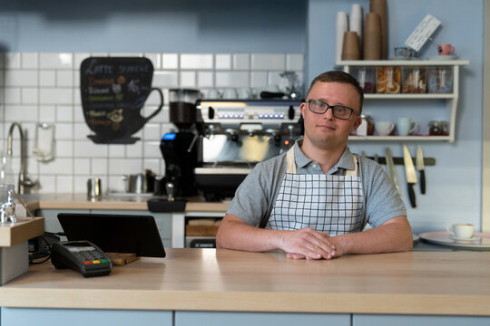 Portrait of caucasian man with down syndrome working in the cafe
