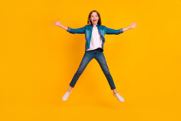 Fototapeta na wymiar Full size photo of overjoyed energetic girl jumping make star figure isolated on yellow color background