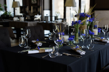 A set of furniture in a cafe. Vase with flowers decor for the restaurant. Black tablecloth