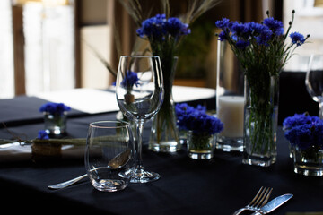 A set of furniture in a cafe. Vase with flowers decor for the restaurant. Black tablecloth